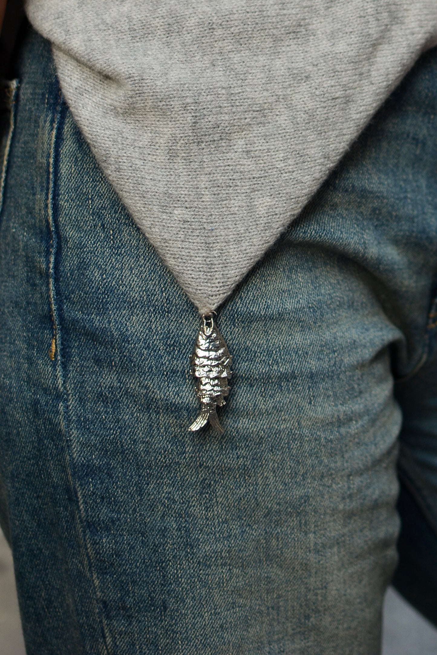 bandana gris en laine avec charm poisson porté à la ceinture par le modèle 