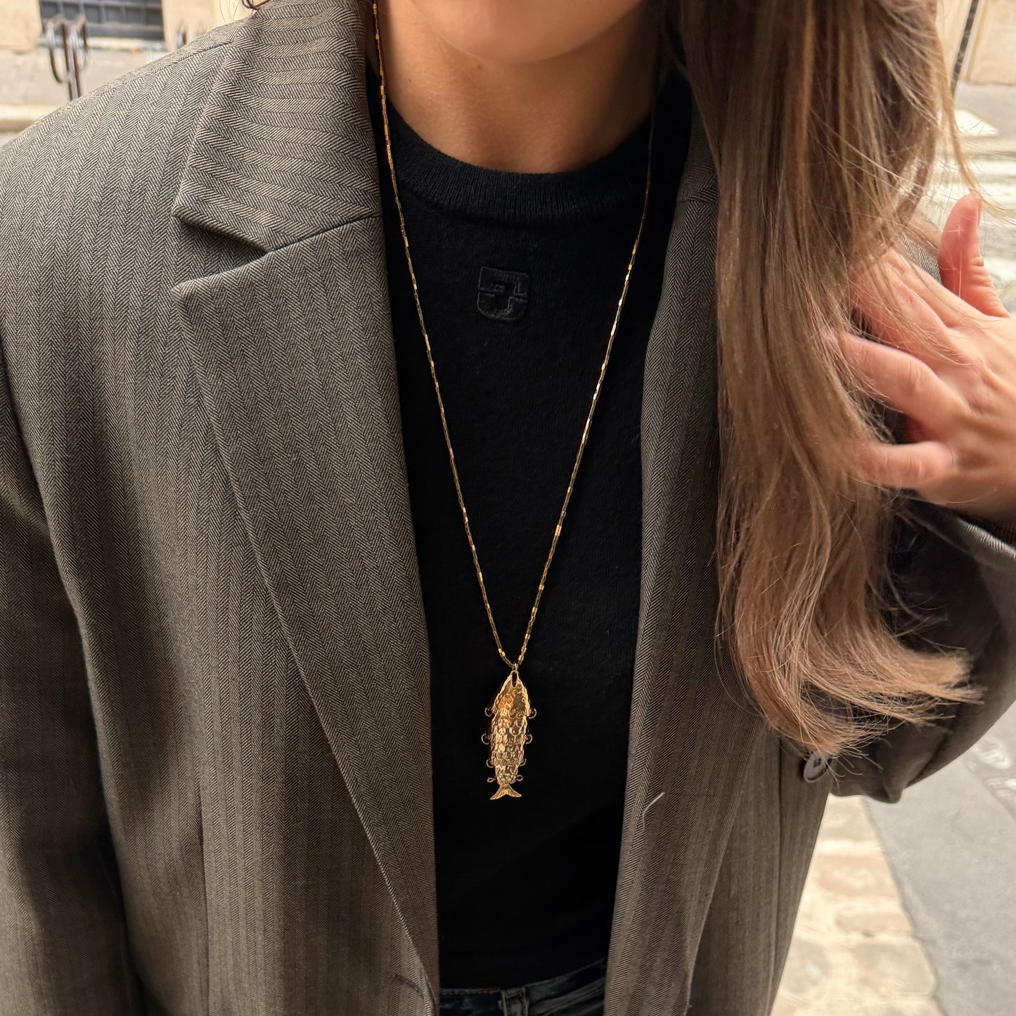 Collier en pierres semi précieuses d'hématite plaquées or et résistantes à l'eau orné d'un charm poisson. 