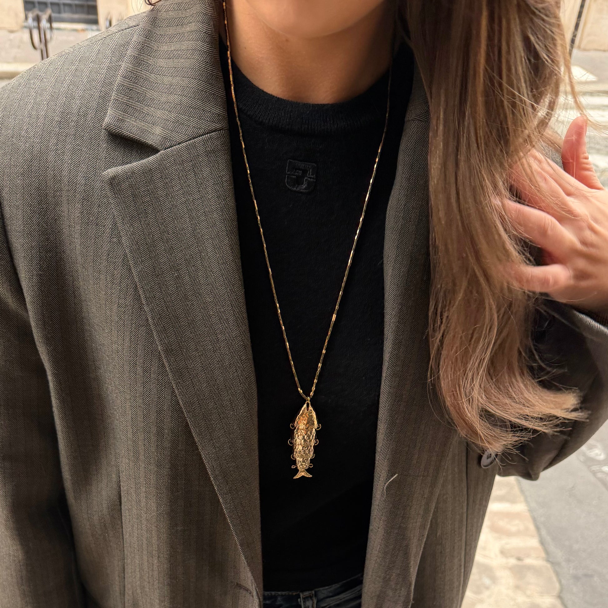 Collier en pierres semi précieuses d'hématite plaquées or et résistantes à l'eau orné d'un charm poisson. 