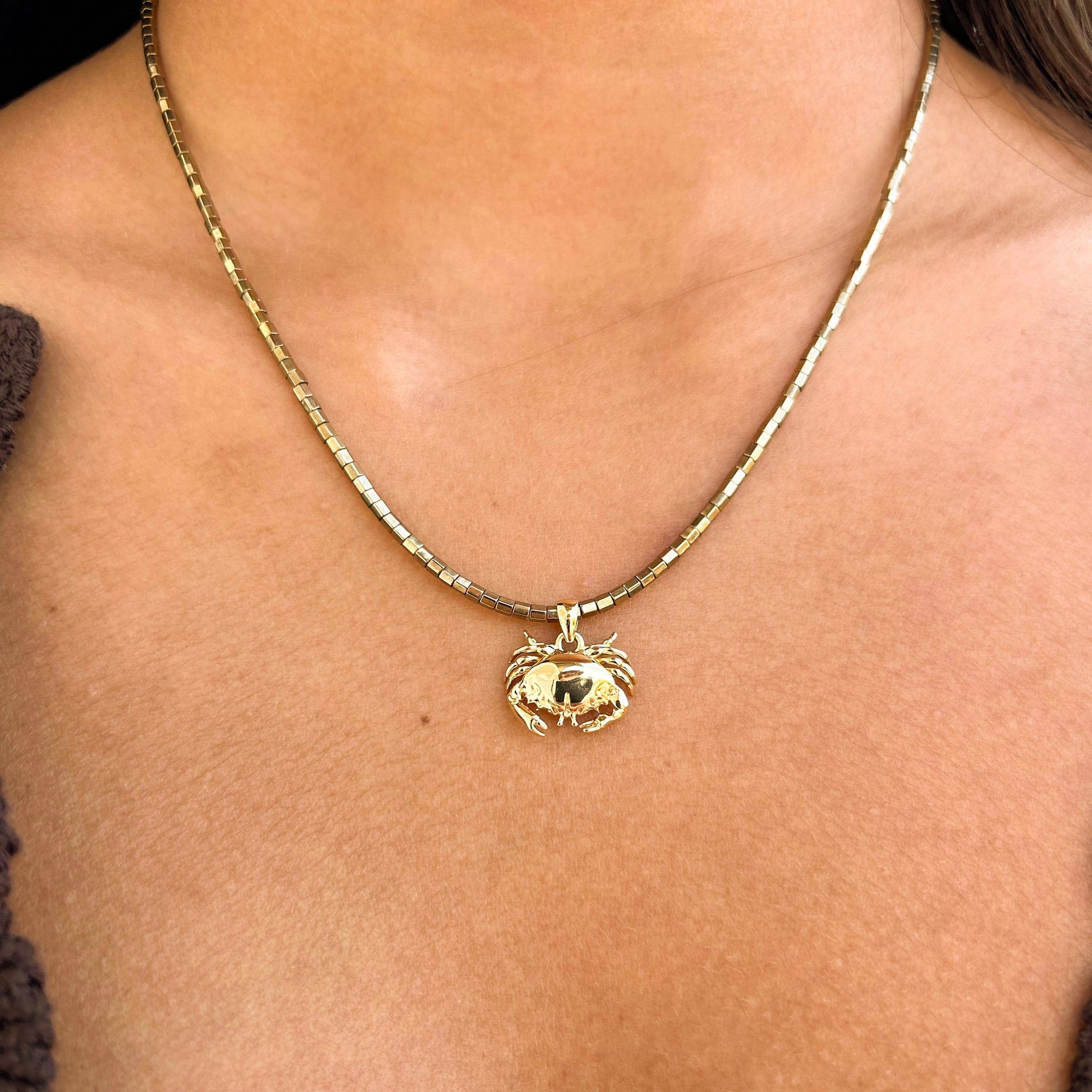 Collier en pierres semi précieuses plaquées or et résistantes à l'eau. orné d'un charm crabe plaqué or. 