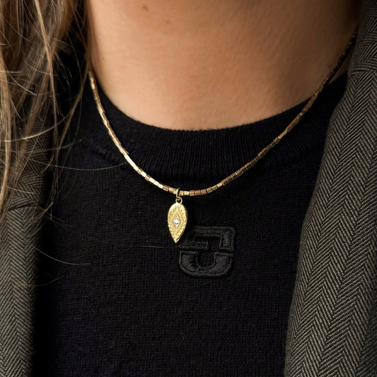 Ce collier est fabriqué à la main dans nos ateliers parisiens à partir de pierres semi précieuses d'hématite plaquées or et résistantes à l'eau. 