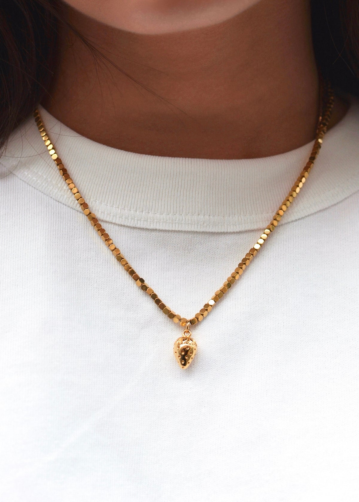collier florence doré et perlé avec charm fraise porté par le modèle